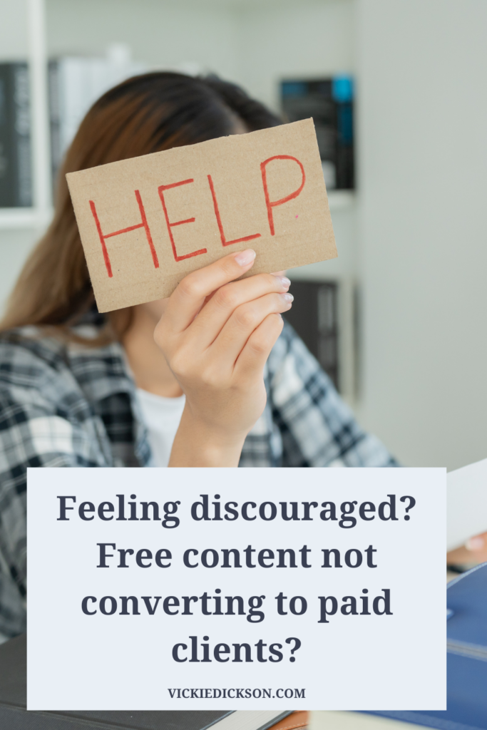 Woman holding a help sign that says Feeling discouraged?  Free content not converting to paid clients? 